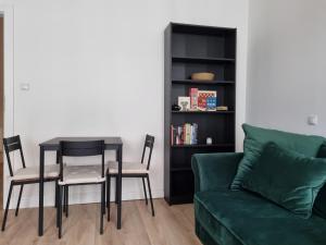 a living room with a green couch and a table and chairs at Apartament w kamienicy in Poznań