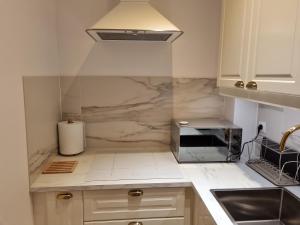 a kitchen with white counter tops and a sink at Apartament w kamienicy in Poznań