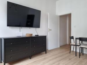 uma sala de estar com uma cómoda preta e uma televisão de ecrã plano em Apartament w kamienicy em Poznań