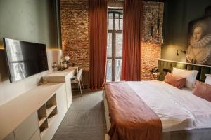 a bedroom with a bed and a desk and a sink at Victoria Deluxe Hotel in Chernivtsi