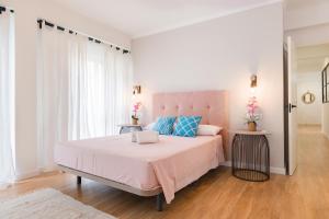 ein Schlafzimmer mit einem rosa Bett und einem Stuhl in der Unterkunft Malagaflat Design Apartment 3 Bedrooms City Centre in Málaga