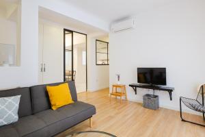 ein Wohnzimmer mit einem Sofa und einem TV in der Unterkunft Malagaflat Design Apartment 3 Bedrooms City Centre in Málaga