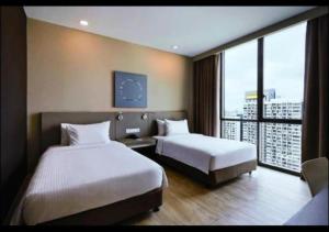 a hotel room with two beds and a large window at Hotel Damansara Perdana - Q in Petaling Jaya