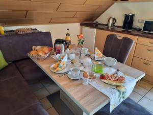 - une table avec des aliments pour le petit-déjeuner dans la cuisine dans l'établissement Haus Am Waldesrand, à Fichtelberg
