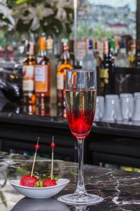 szklankę wina siedzącą na stole z miską truskawek w obiekcie Arts Hotel Harbiye - Special Class w Stambule