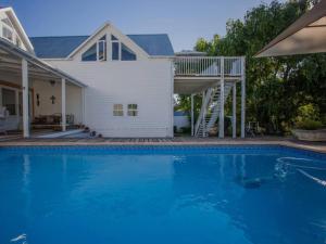 a house with a swimming pool in front of a house at Riverside Country House in Swellendam