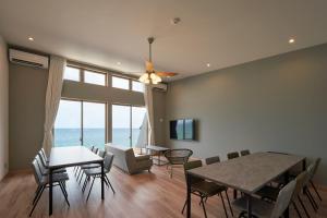 a dining room with a table and chairs and the ocean at ALFACIO RESORT STAY ITOSHIMA in Itoshima