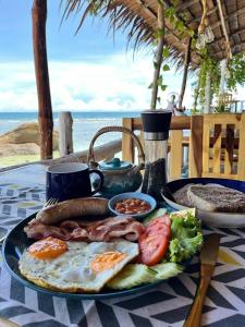 una bandeja de desayuno con huevos, salchichas y verduras en una mesa en Secret Place Hotel and Restaurant, en Haad Yao