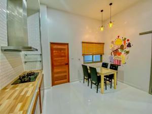 a kitchen with a wooden table and chairs and a dining room at In Town Pool Villa Krabi in Ban Khlong Chi Lat