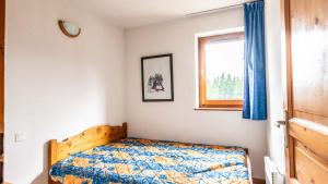 a bedroom with a bed and a window at Les Sitelles - 11 - Piscine Appart 6 pers in Morillon