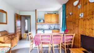 uma cozinha e sala de jantar com mesa e cadeiras em Les Sitelles - 11 - Piscine Appart 6 pers em Morillon