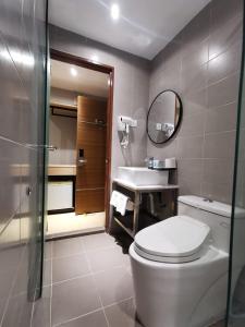 bagno con servizi igienici, lavandino e specchio di OCEAN HOTEL a Labuan