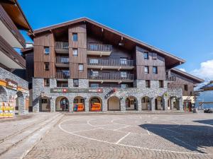 a large building with a basketball court in front of it at Arcades-39- Studio pied des pistes-4 pers in Doucy