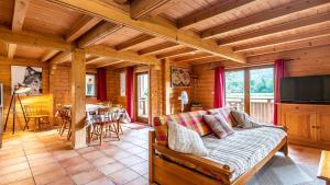 a living room with a couch and a television in a cabin at Bois de Champelle- 94 Magnifique Chalet-10 pers in Morillon