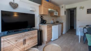 a kitchen with a large flat screen tv on a entertainment center at Grand Morillon - 104 - Montagne Belle Vue Studio 4 in Morillon