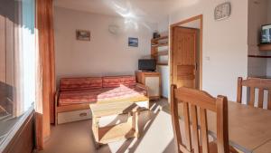ein kleines Schlafzimmer mit einem Bett, einem Tisch und einem Schreibtisch in der Unterkunft Les Eterlous - 39- Appart pied des pistes 6 pers in Morillon