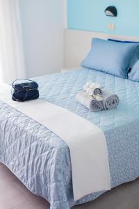Una cama con toallas y una bolsa. en Hotel Platinum, en Rímini