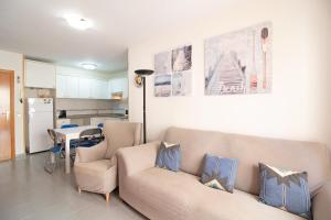 un soggiorno con divano e tavolo e una cucina di Global Properties, Atico con gran terraza y barbacoa a Canet de Berenguer