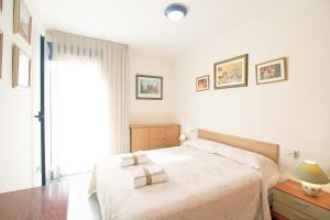 una camera da letto con un letto e due asciugamani di Global Properties, Atico con gran terraza y barbacoa a Canet de Berenguer