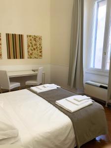 a bedroom with a bed with two towels on it at Vicolo Doria Apartment in Rome