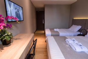 a hotel room with two beds and a tv at OCEAN HOTEL in Labuan