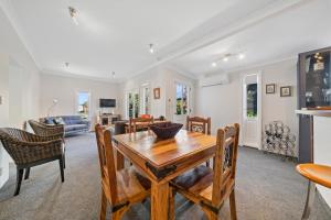 - un salon avec une table et des chaises en bois dans l'établissement Te Kawa Cottage - Martinborough Holiday Home, à Martinborough