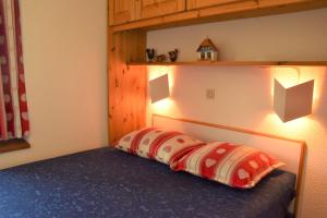 1 dormitorio con 1 cama con 2 lámparas en Necou 721 en Les Menuires