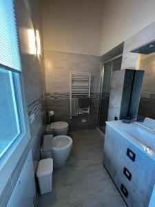 uma casa de banho com um lavatório, um WC e uma banheira em Marinella House em Sarzana
