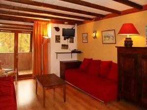 a living room with a red couch and a tv at Appartement Les Orres, 2 pièces, 6 personnes - FR-1-322-203 in Les Orres