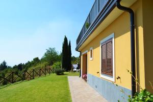 a yellow building with a window and a grass yard at L'Infinito Agriturismo - Rooms & Breakfast in SantʼAlfio