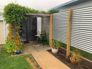 a patio with a table and some plants at Jetty Road Granny Flat in Normanville