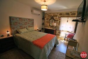a bedroom with a bed and a tv in a room at Casa dos Ferros 