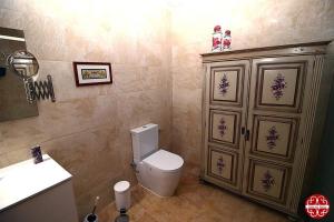 a bathroom with a toilet and a sink and a cabinet at Casa dos Ferros 