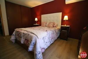 a bedroom with a large bed and two lamps at Casa dos Ferros 