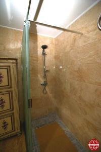 a shower with a glass door in a bathroom at Casa dos Ferros 