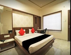 a bedroom with a large bed with red pillows at Hotel Sun N Star, Satna in Satna