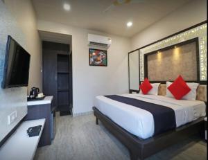 a hotel room with a bed and a flat screen tv at Hotel Sun N Star, Satna in Satna