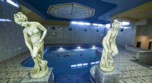 zwei Statuen von Menschen in einem Schwimmbad in der Unterkunft Hotel Real de Castilla in Tordesillas