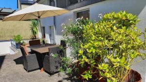 a patio with a table and umbrella and plants at Georgs Ferienhaus in Zeltingen-Rachtig