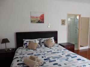 a bedroom with a bed with a blue and white comforter at Donsonhome in Glen Waverley