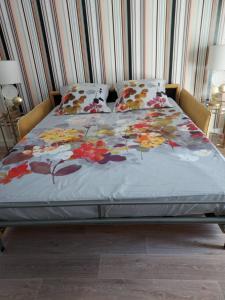 un letto con un piumone floreale sopra di esso di Rez-de-chaussée privatif spacieux 3* d'une villa centre ville a Hyères