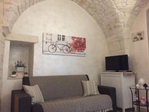 salon z kanapą i rowerem na ścianie w obiekcie LA NICCHIA DI PAOLA w mieście Ostuni