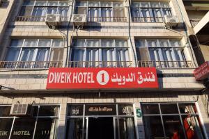 a building with a red sign on the side of it at Dweik Hotel 1 in Aqaba