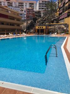 a large blue swimming pool with a water slide at Olivia SunSet Blanco in Puerto de Santiago