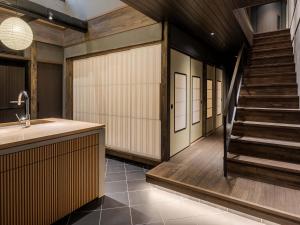 La salle de bains est pourvue d'un escalier et d'un lavabo. dans l'établissement Kanata Machiya House, à Kanazawa