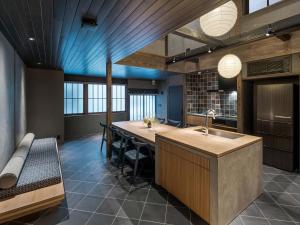 a kitchen with a large island with a sink at Kanata Machiya House in Kanazawa