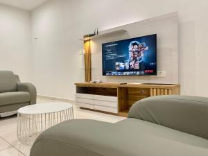 a living room with a flat screen tv on a wall at Langkawi Cozy Holiday Home at Taman Simfoni by Zervin in Kuah