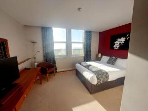 a hotel room with a bed and a television at The New Admiralty Hotel Ltd in Portland