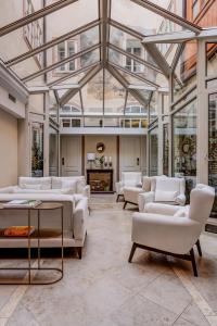 a living room with white couches and a glass ceiling at Hotel Nerudova 211 in Prague