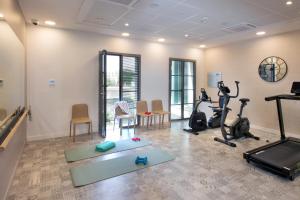 einen Fitnessraum mit Laufbändern und Trainingsgeräten in einem Zimmer in der Unterkunft DOMITYS SARIA in Serris